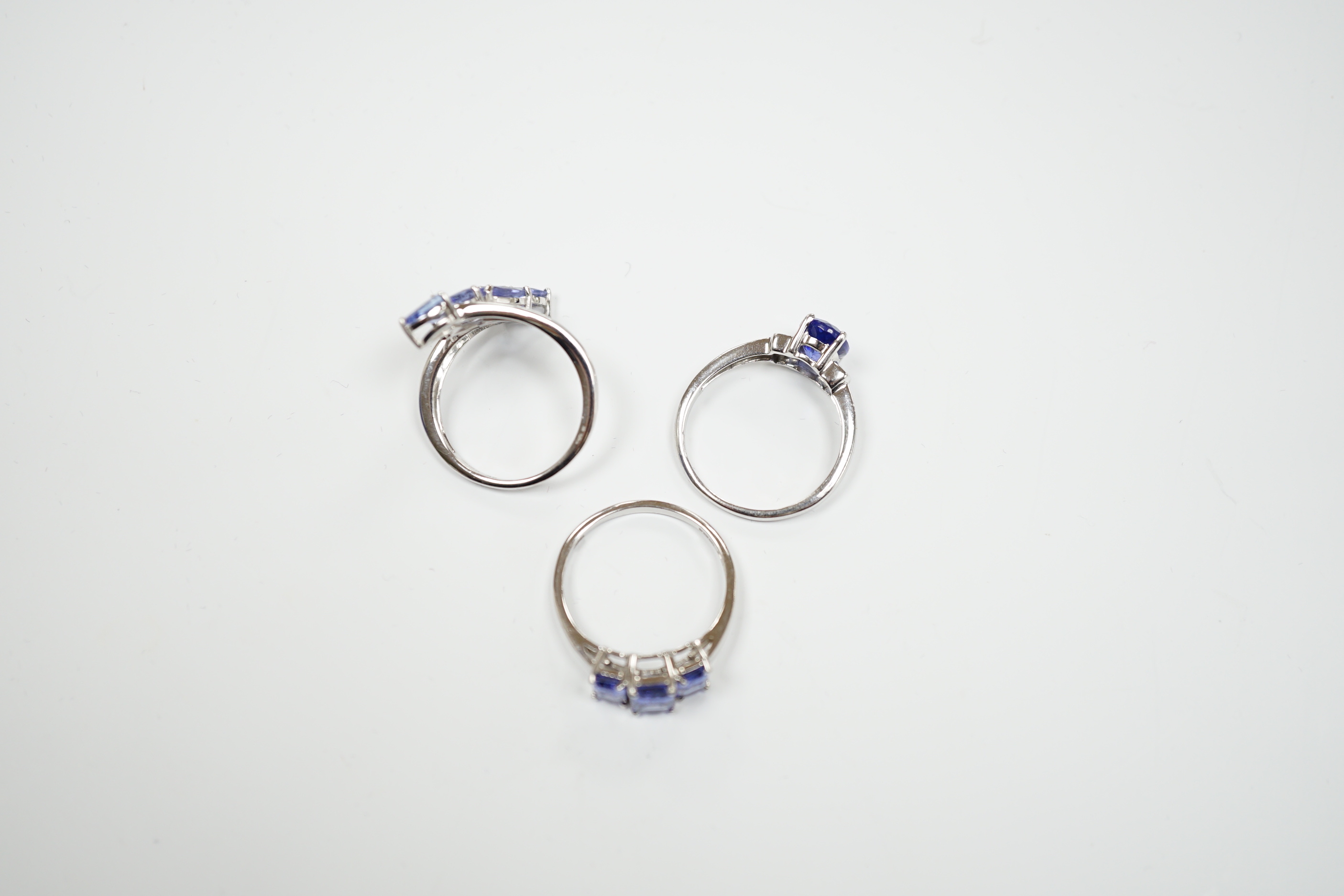 Three assorted modern 9ct white gold and tanzanite set dress rings, gross weight 8.4 grams.